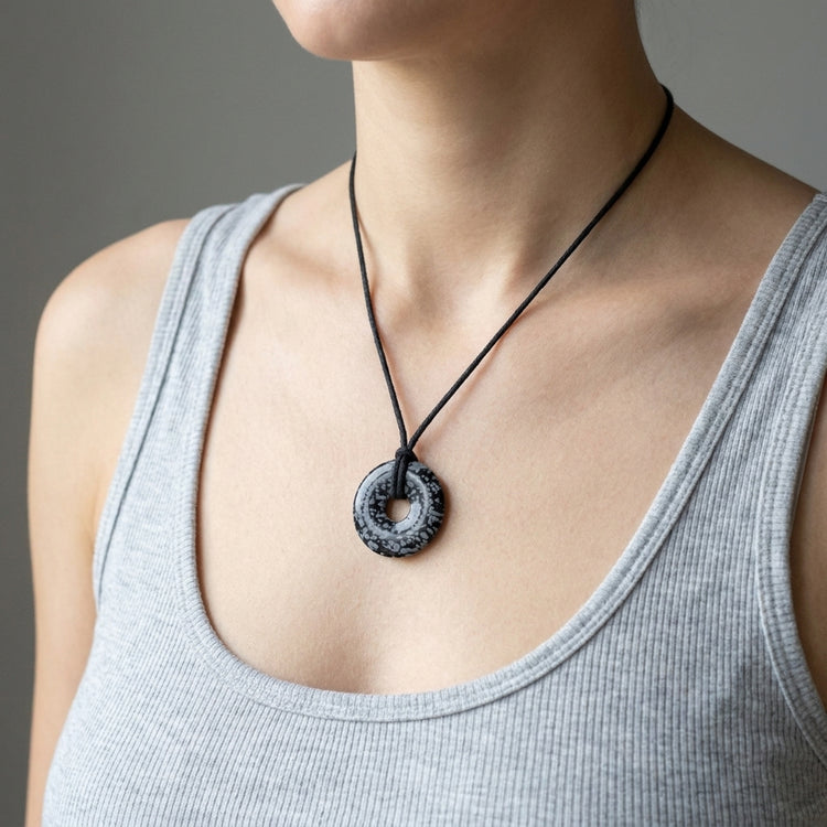 Schneeflockenobsidian Donut | 30 mm Anhänger + Baumwollband — Lifestyle-Tragebild