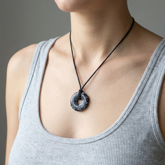 Schneeflockenobsidian Donut | 30 mm Anhänger + Baumwollband — Lifestyle-Tragebild